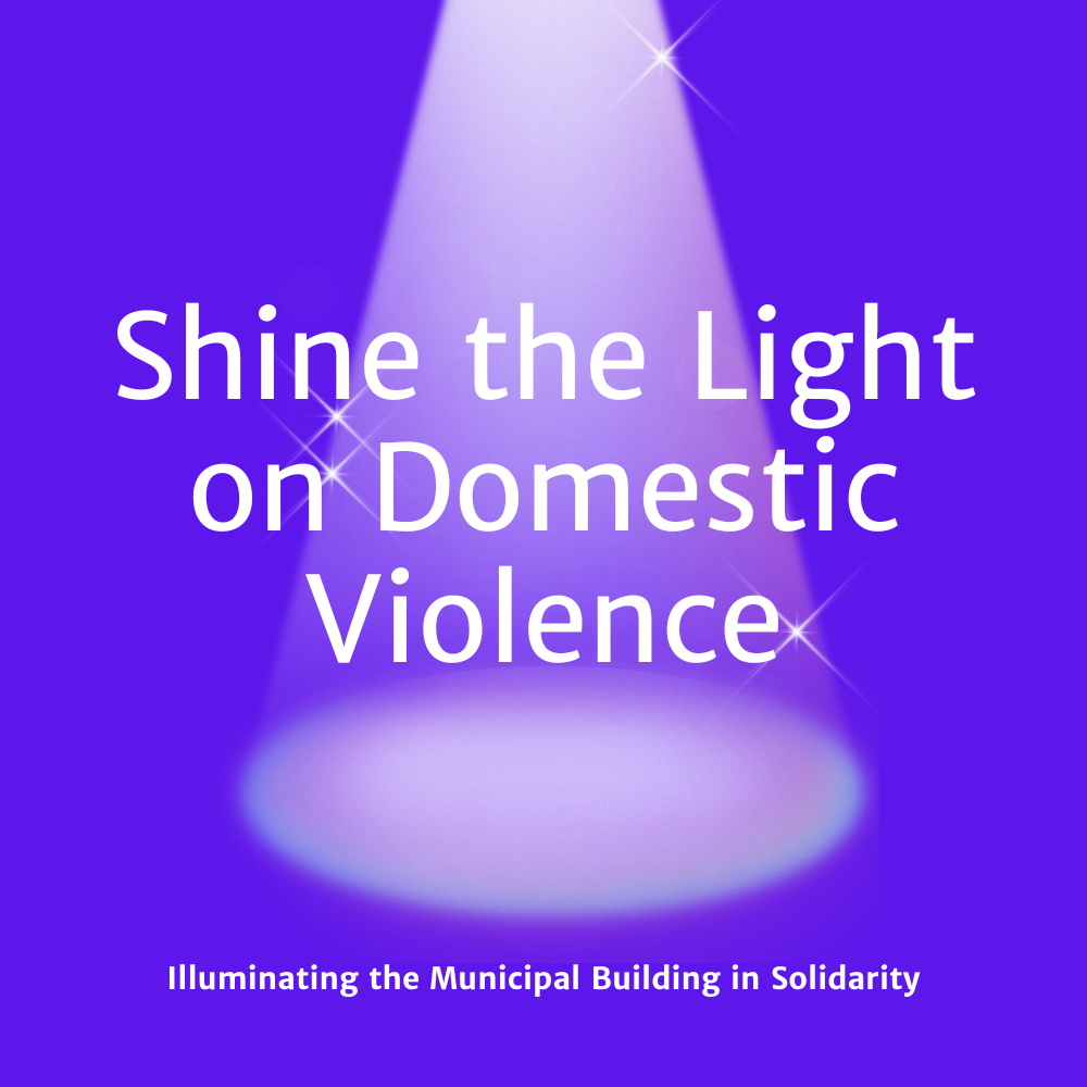 A purple spotlight and background with white text reading, "Shine the Light on Domestic Violence. Illuminating the Municipal Building in Solidarity."