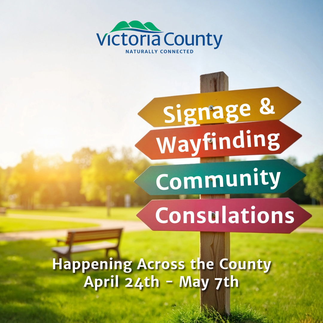 Park scene with a wooden signpost featuring four colorful directional signs. The signs read "Signage & Wayfinding," "Community," and "Consultations." The background includes trees, grass, and a bench. Text at the bottom reads: "Happening Across the County April 24th - May 7th."